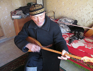 ドンブラという民族楽器を演奏するカザフ人