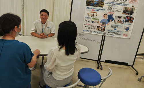 大学生活について来場者に説明する学生.png